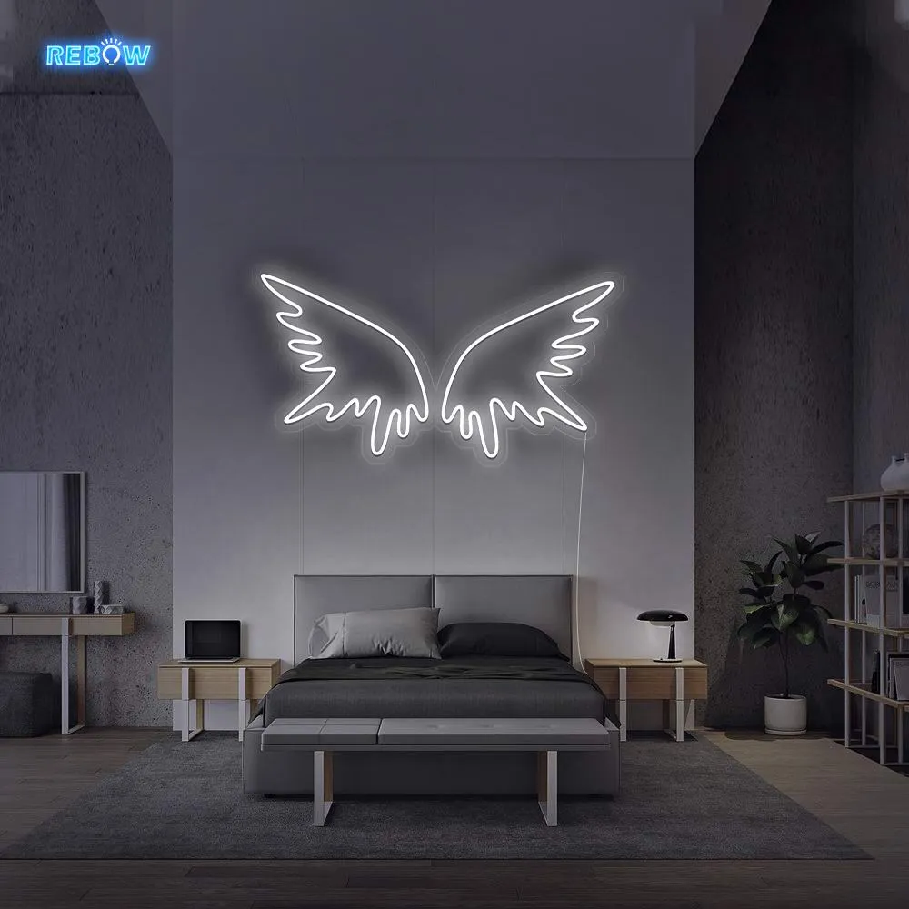 White LED neon angel wings above a bed in a calm bedroom